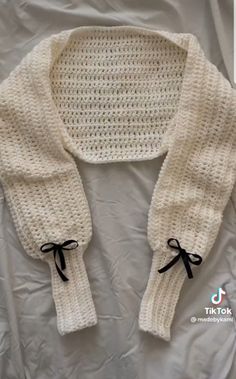 a white knitted sweater with black bow ties