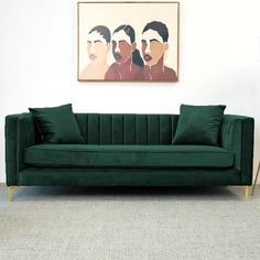 a green velvet couch in front of a painting