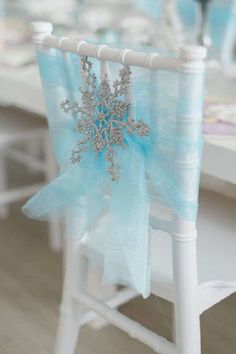 a snowflake decoration on the back of a chair at a wedding or party