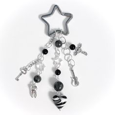 a star shaped key chain with black and white charms hanging from it's side