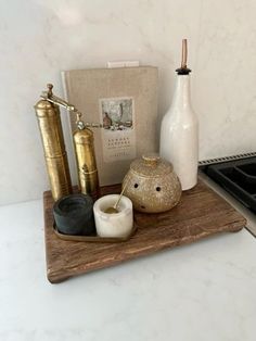 an assortment of items sitting on a wooden tray in front of a stove top oven