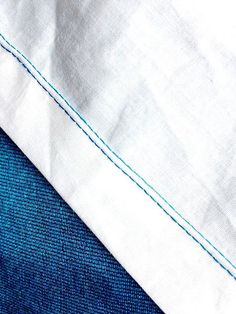 closeup of blue and white linens with stitching on the bottom part of them