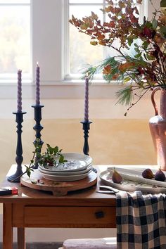 the table is set with candles and plates