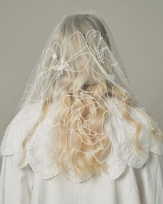 a woman wearing a veil with flowers on it