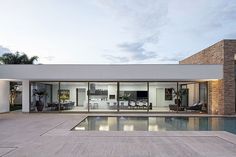 a house with a swimming pool in front of it and an outdoor living area on the other side