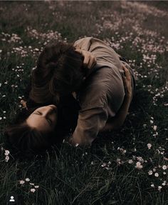 a woman laying on her back in the grass