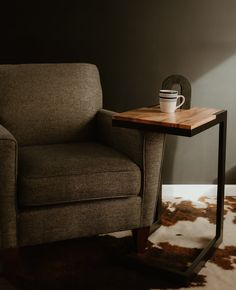 a chair with a wooden table on it in front of a gray wall and cow hide rug