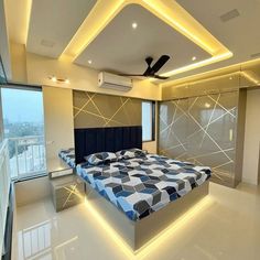 a large bed sitting in the middle of a bedroom next to a window with a ceiling fan