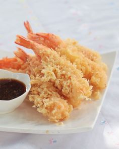 a white plate topped with shrimp and dipping sauce