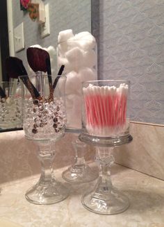 two wine glasses filled with candy canes and marshmallows on a counter