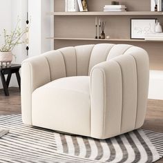 a white chair sitting on top of a rug next to a book shelf filled with books