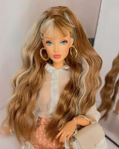 a doll with long blonde hair holding a purse