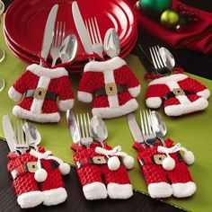 a table topped with lots of silverware covered in red and white santa clause decorations