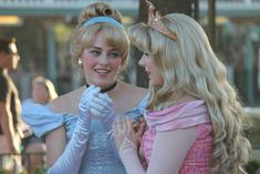 two women dressed as princesses standing next to each other