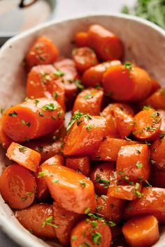 a bowl filled with cooked carrots and parsley