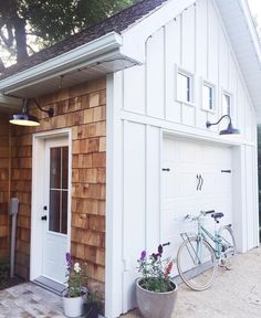 a bicycle is parked in front of a small building with a white door and window