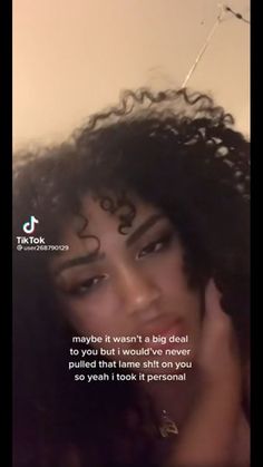 a woman with curly hair is talking on her cell phone