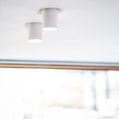 two lights are hanging from the ceiling in a room with white walls and wood trim