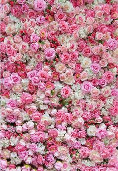 many pink and white flowers are arranged in the shape of a flower arrangement on display