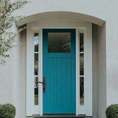 a blue front door on a white house