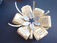 an origami flower made out of books on a blue table with other items in the background