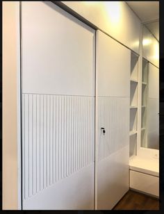 the interior of a bathroom with white closet doors and shelving unit in front of a mirror