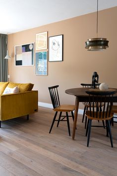 a living room filled with furniture next to a wooden table and two chairs on top of a hard wood floor