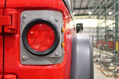 the front end of a red truck with its lights on in a factory building or warehouse