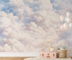 a baby's room with clouds and stars painted on the wall