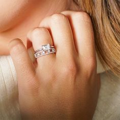 a woman's hand with a diamond ring on her left hand and two diamonds in the middle