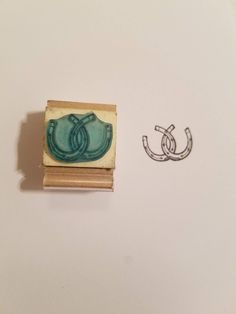 a rubber stamp with the letter c on it next to a drawing of a horseshoe