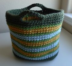 a crocheted bag sitting on top of a white table next to a window