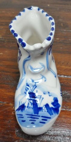 a blue and white vase sitting on top of a wooden table