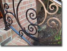 an iron gate on the side of a brick building