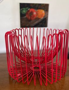 a red sculpture sitting on top of a wooden table