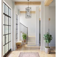 a hallway with white walls, wooden floors and plants on the far side of the room