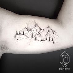 a man's arm with mountains and trees tattoo on the left side of his arm