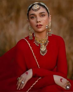 a woman in a red dress with gold jewelry