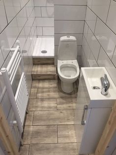 a small bathroom with a toilet, sink and radiator next to each other