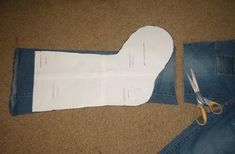 scissors are laying next to the cut out jeans