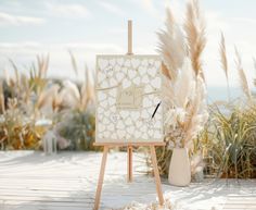 an easel with a wedding date written on it in front of some pamodia