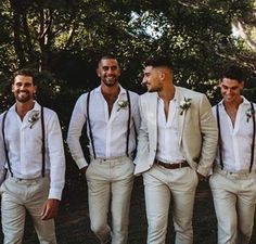 a group of men standing next to each other wearing white shirts and suspender ties