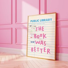 a book was better poster on the floor in front of a pink wall with writing