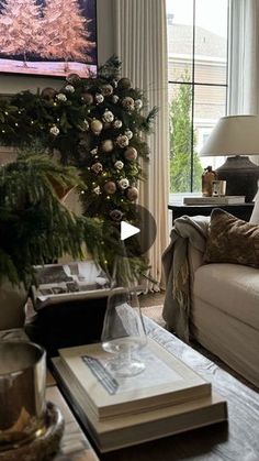 a living room filled with furniture and a christmas tree in the window sill next to a couch