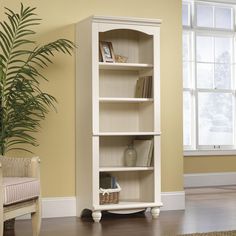 a white bookcase sitting on top of a hard wood floor