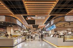 people are walking through an indoor food court