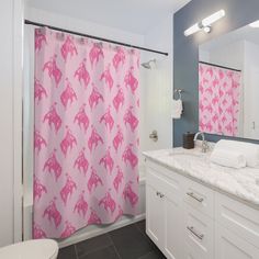 a pink shower curtain in a bathroom next to a white toilet and sink under a mirror