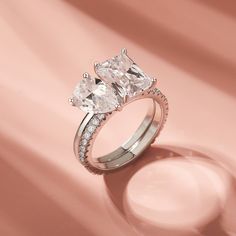 three stone engagement ring on pink background