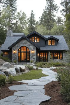 a house that is in the woods with stone walkway leading up to it's front door