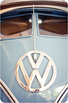 the vw emblem is hanging from the front of a blue car